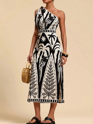 Tropical print one-shoulder midi dress with defined waist and side slits.
