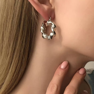 Textured hoop earrings in silver with a twisted design.