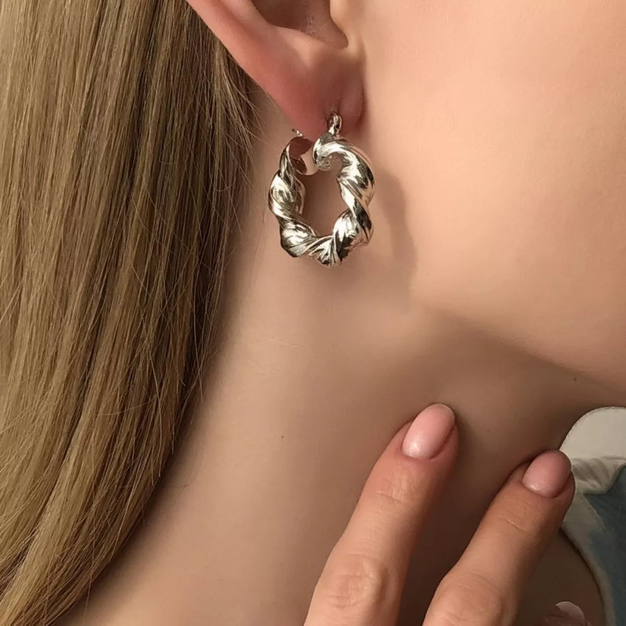 Textured hoop earrings in silver with a twisted design.
