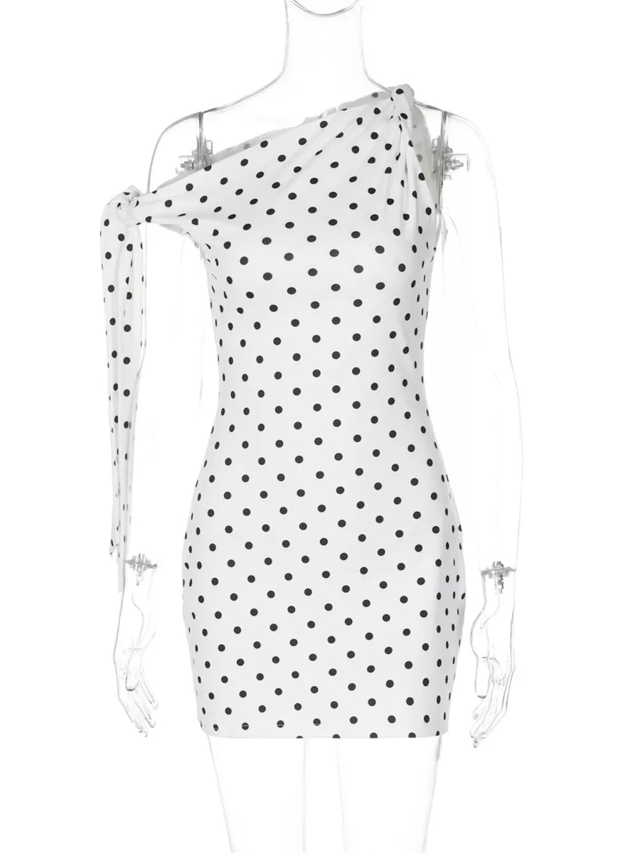 White polka dot mini dress with asymmetrical neckline and bow detail on one shoulder.
