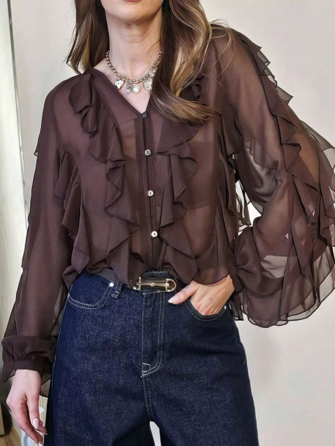 Brown sheer long-sleeve blouse with cascading ruffles and button front.