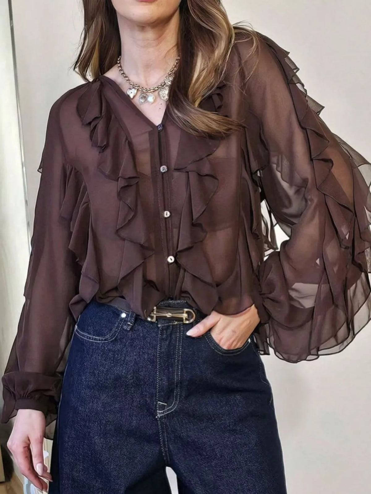 Brown sheer long-sleeve blouse with cascading ruffles and button front.