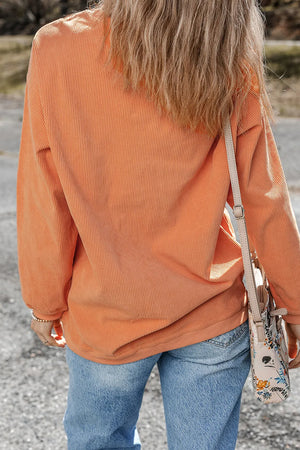 Orange corduroy oversized pullover sweatshirt with long sleeves.