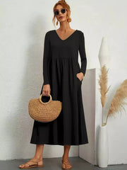 Black midi dress with V-neck, long sleeves, pockets, and relaxed fit.