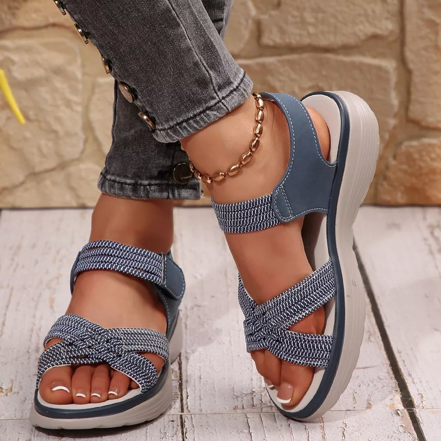 Blue woven criss-cross platform sandals with adjustable straps and a thick sole.