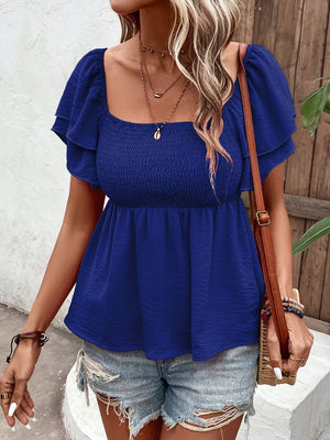Blue textured smocked blouse with square neckline and ruffled sleeves.