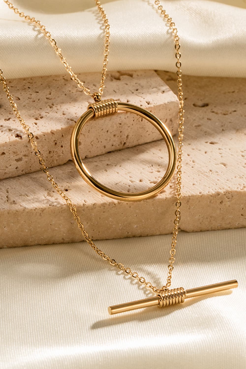 Gold double-layered necklace with geometric circle and bar pendants, 18K gold-plated.