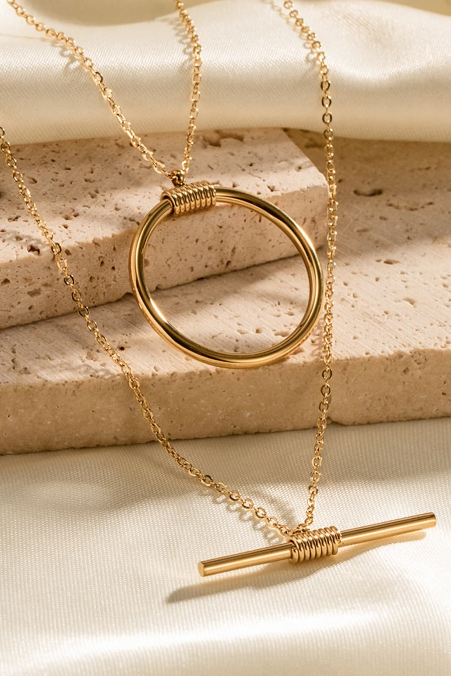 Gold double-layered necklace with geometric circle and bar pendants, 18K gold-plated.