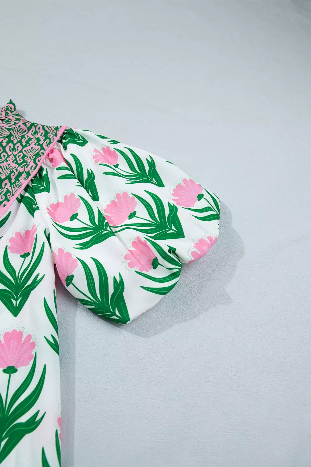 White polyester blouse with pink floral print and puff sleeves.