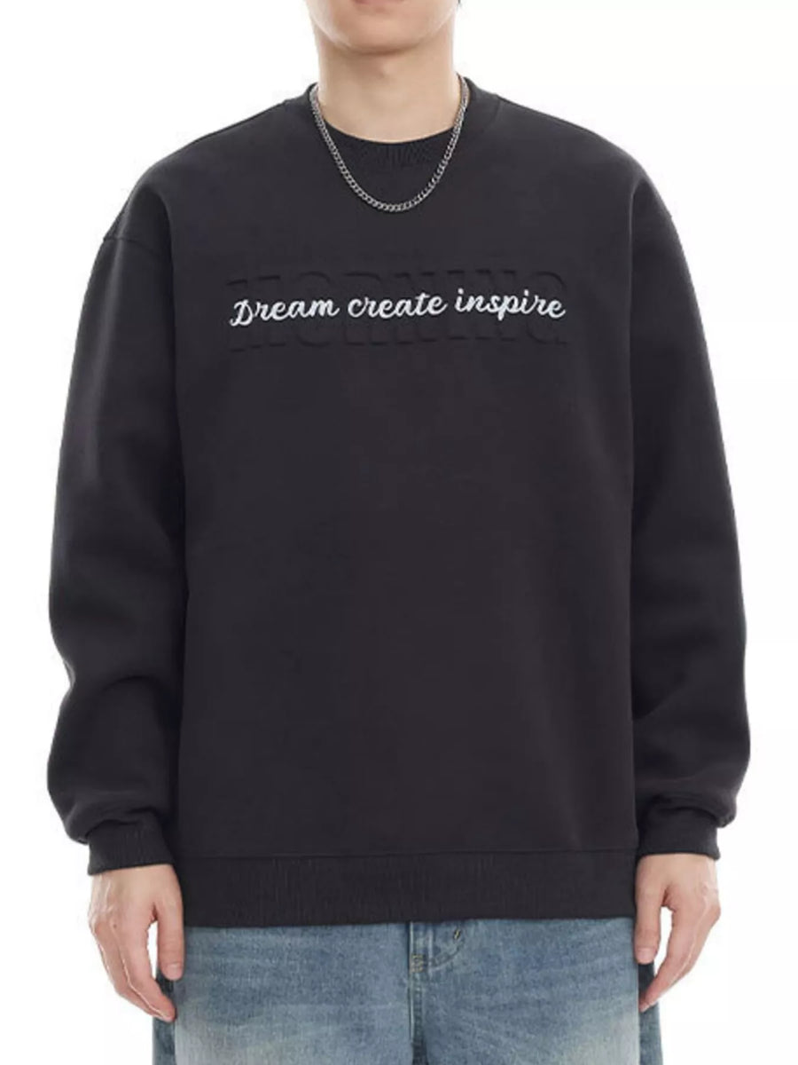 Black oversized crew-neck sweatshirt with embroidered "Dream create inspire" text