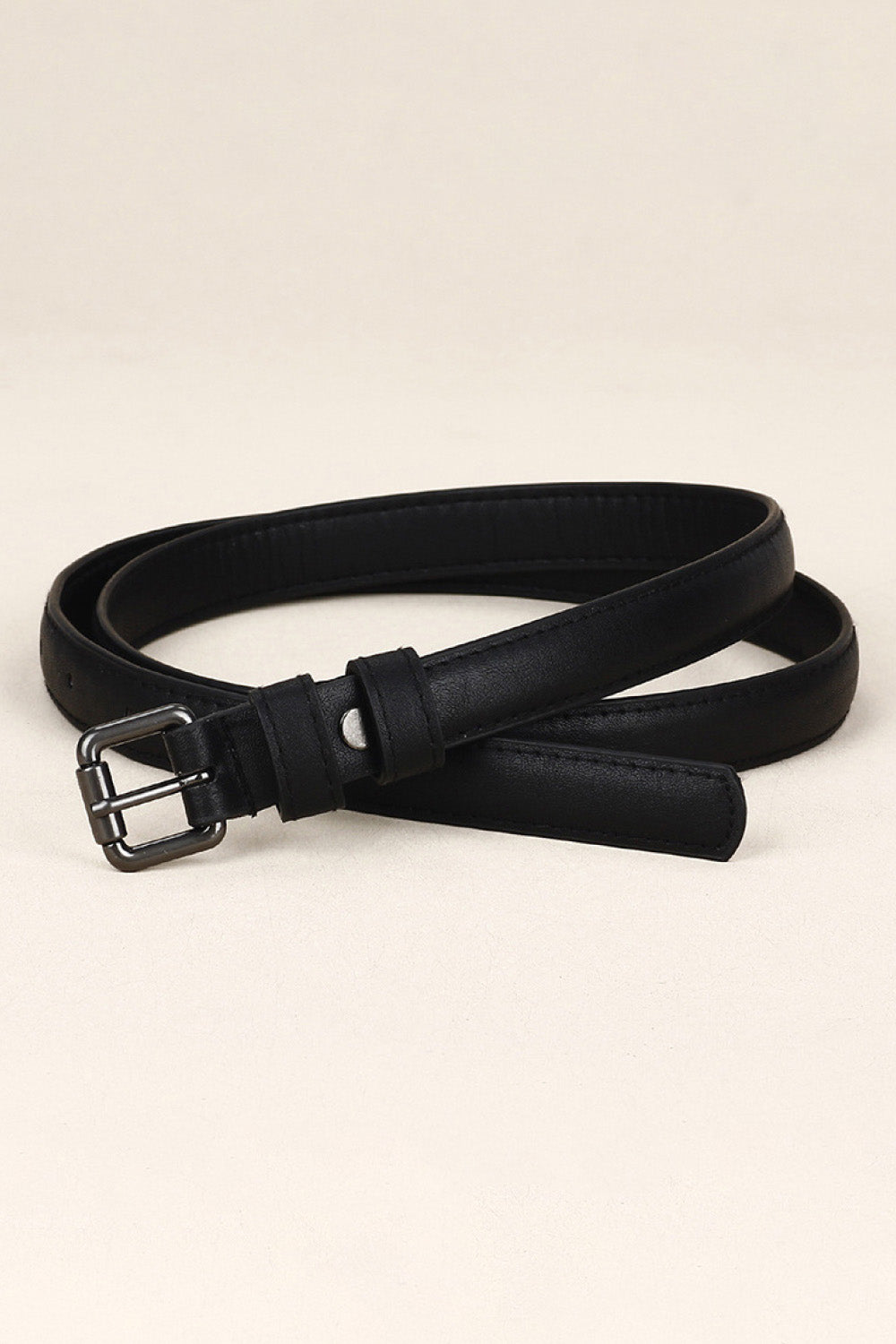 Slimline black leatherette belt with a silver buckle and keeper loop.