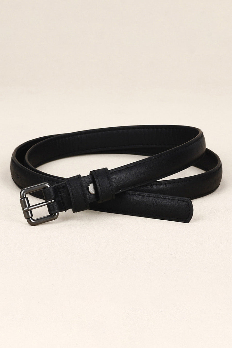 Slimline black leatherette belt with a silver buckle and keeper loop.