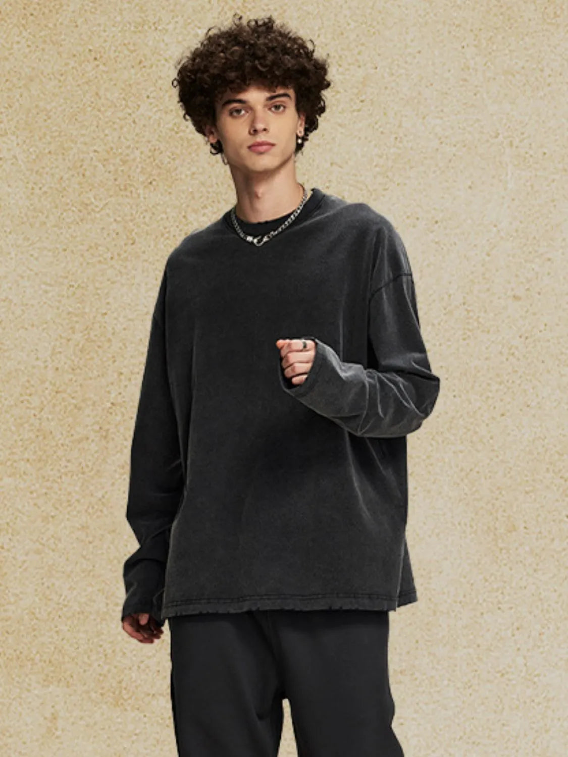 Oversized black washed cotton long sleeve t-shirt with distressed hem and crew neck.