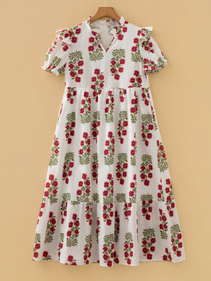 V-neck mini dress with pockets in white with red floral print, short sleeves, and tiered skirt.