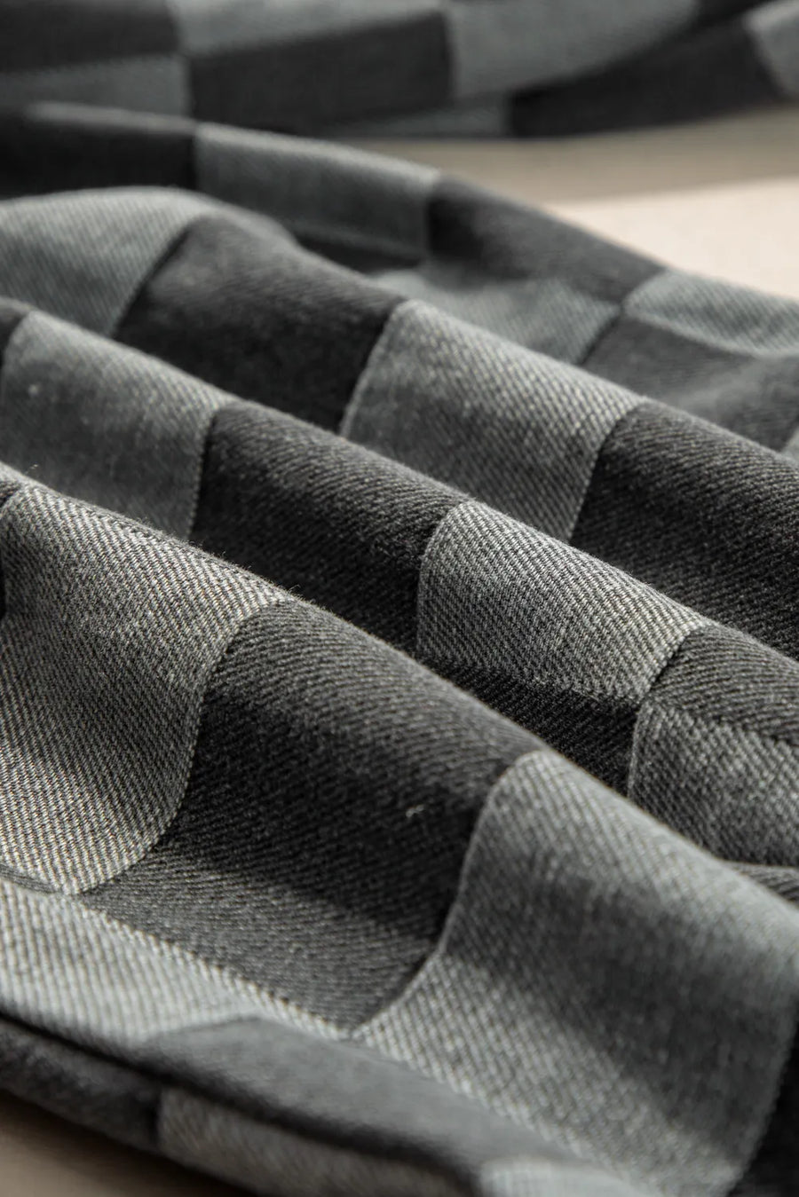 Checkerboard denim wide leg trousers in dark gray with a textured weave.