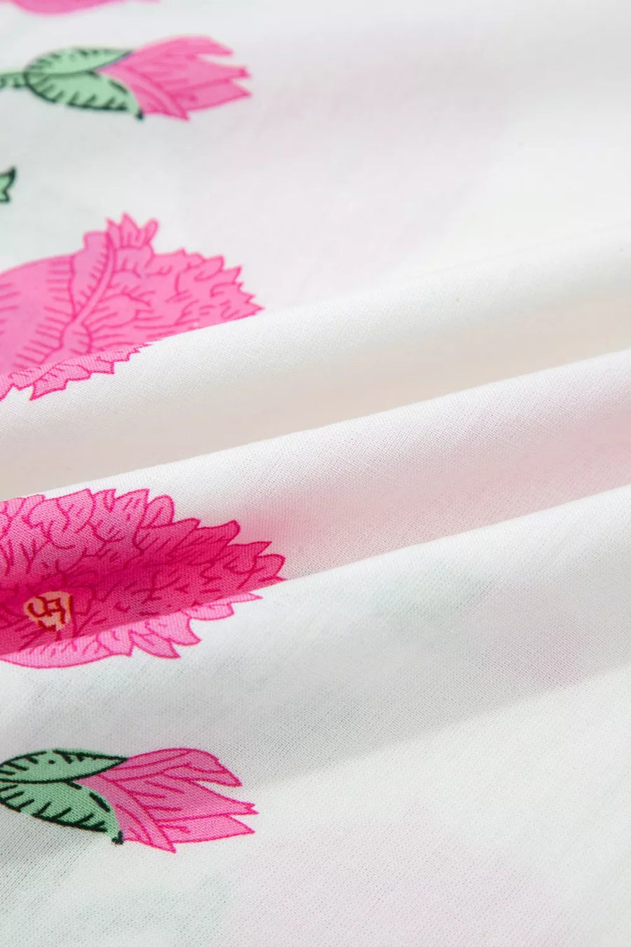 White cotton blouse with vibrant pink floral print and green leaves