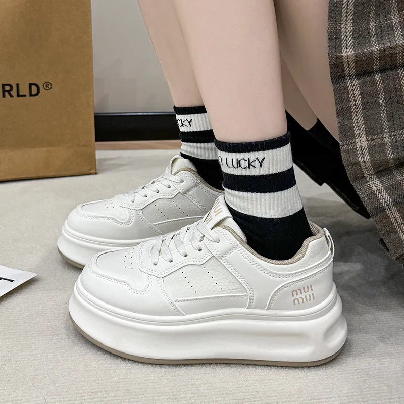 White platform court sneakers with contrast detail and beige trim.