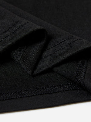 Black t-shirt detail showing fabric texture and stitched hem.