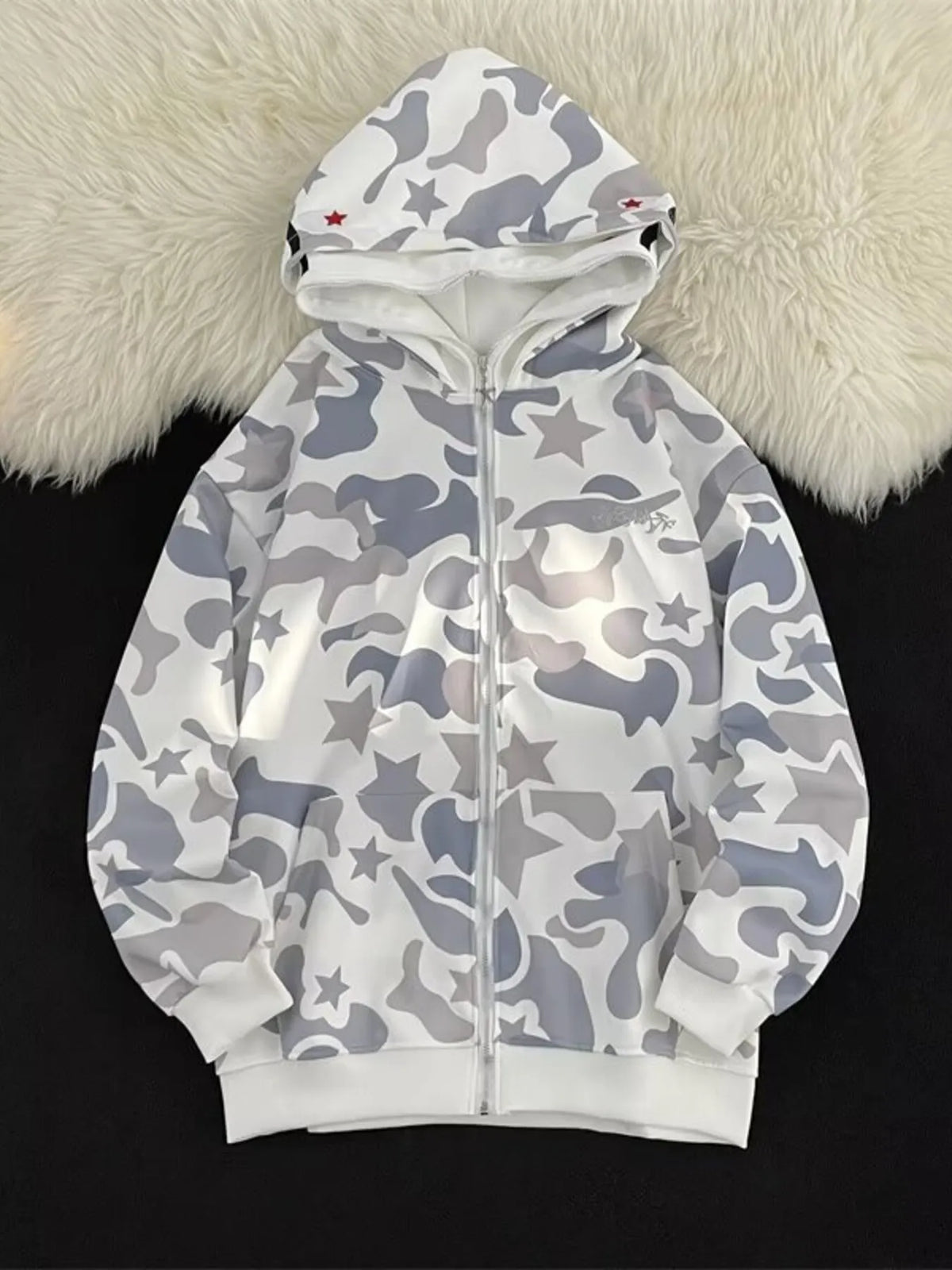 Off-white camo print zip-up hoodie with stars and red accents on the hood.