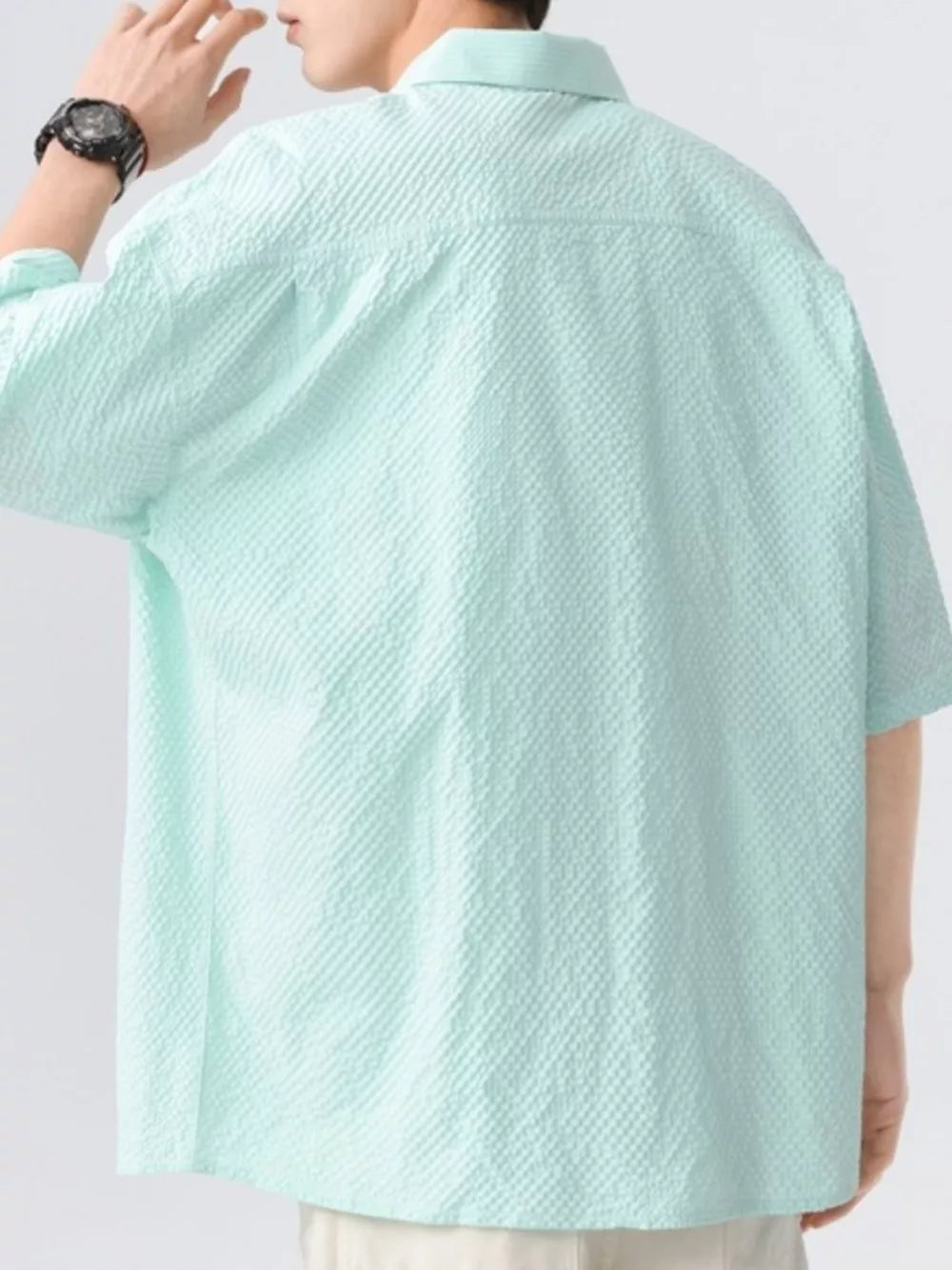 Men's mint green short-sleeve shirt with textured fabric and buttoned collar.