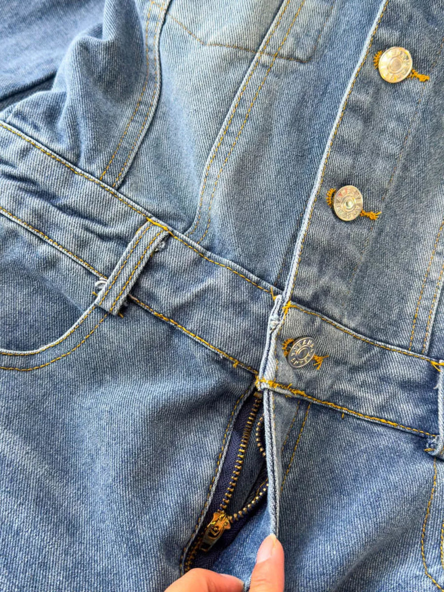 Chic buttoned denim jumpsuit with pockets and zipper detail in light blue cotton fabric.