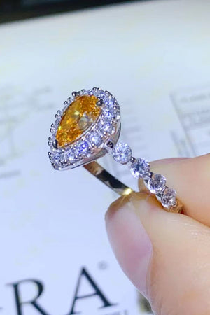 Gold halo ring with pear-cut amber gemstone and diamond accents.