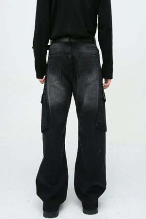 Baggy black denim cargo pants with zipper pockets and a faded wash.