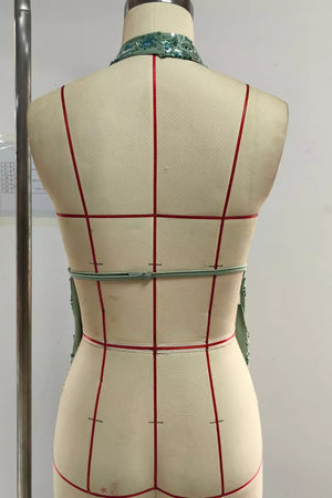 Sequin embellished collar on a light green sleeveless dress with a cinched waist detail.