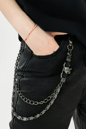 Black chain belt with skull detail and silver hardware, worn with black jeans.