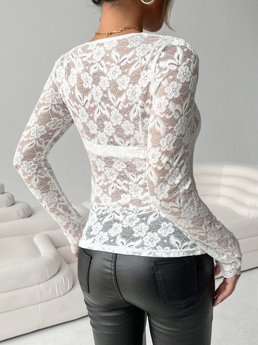 White scalloped lace bodysuit with long sleeves and floral pattern.