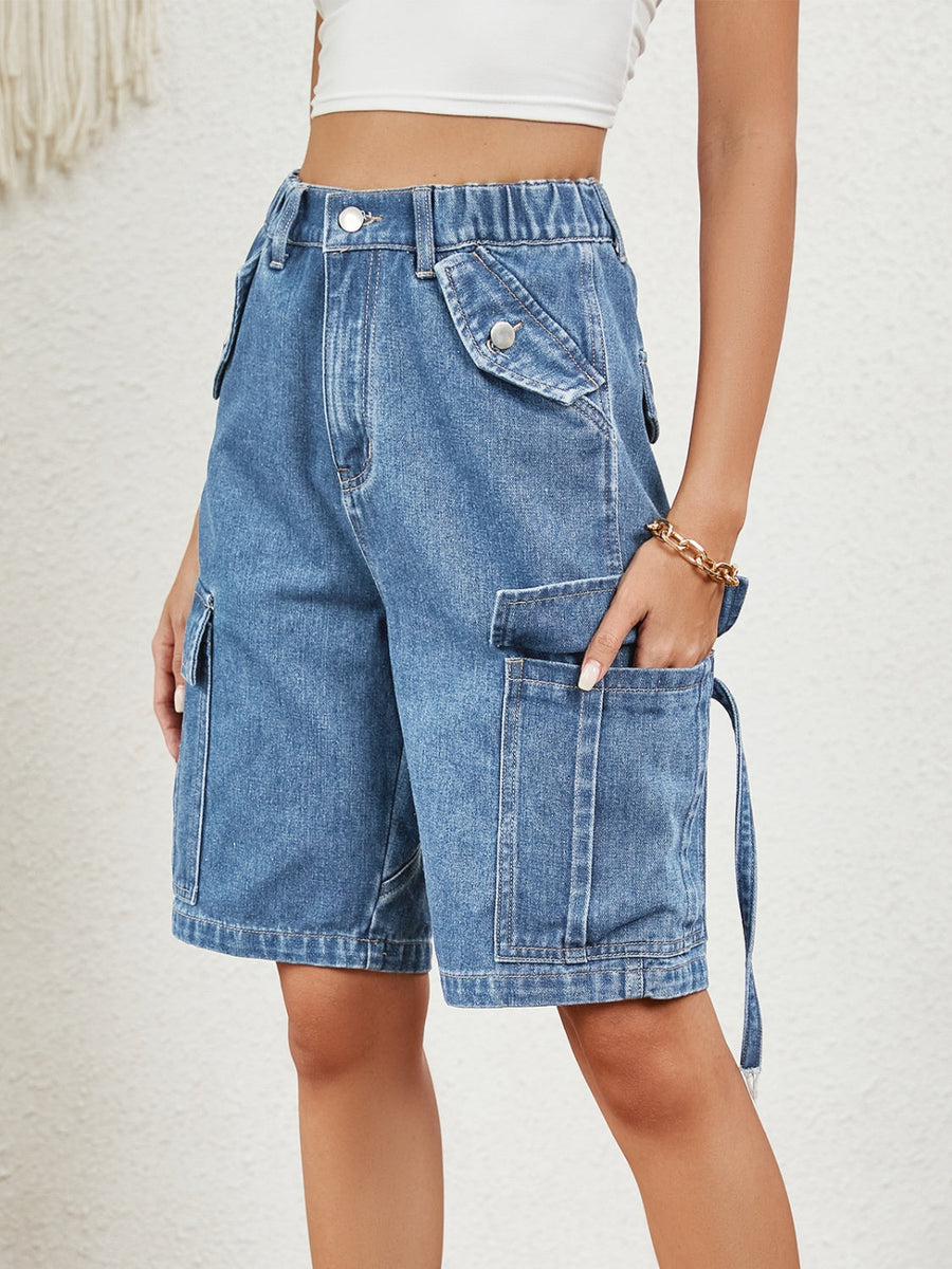 Medium wash denim cargo bermuda shorts with buttoned flap pockets and tie detail.