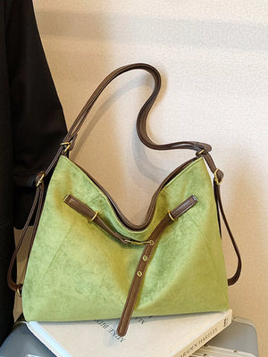Green suede tote bag with brown trim and buckle details.