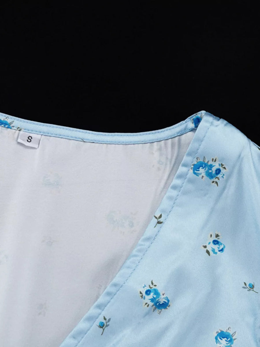Light blue satin floral print v-neck wrap dress with a light blue trim.