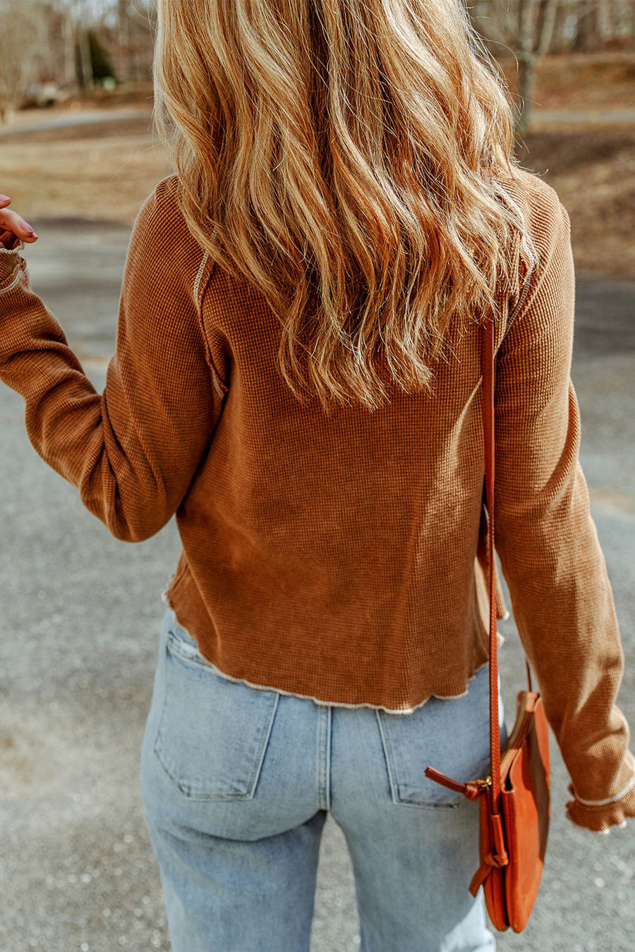 Caramel waffle knit raglan sweater with ruffled cuffs and raw hem detail.