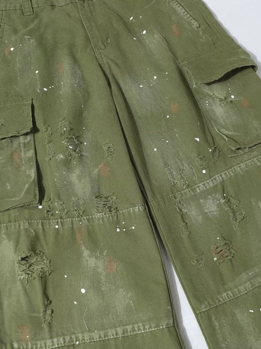 Green distressed cargo pants with paint splatter accents and ripped details.