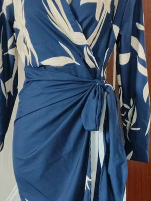 Belted wrap midi dress in navy with a white leaf print, featuring a tie waist and long sleeves.