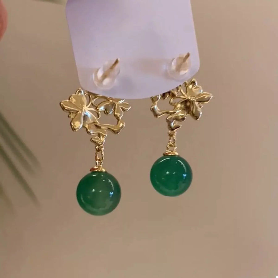 Dark green pearl drop earrings with gold floral accents.