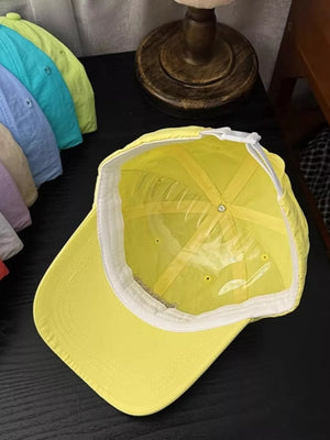 Yellow cotton baseball cap with adjustable strap and embroidered detail.