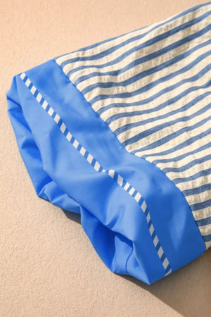 Blue and white striped shirt with blue color block sleeve detail and decorative stitching.