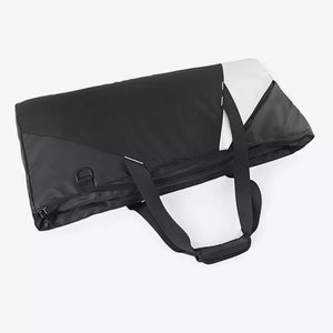 Modern color block travel bag in black with white accents and dual handles.