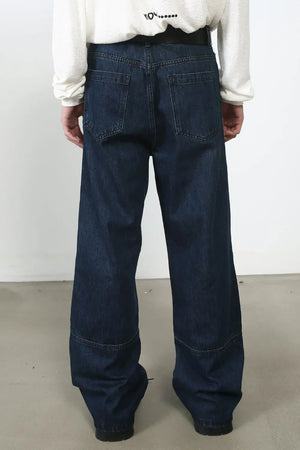 Dark wash denim wide-leg jeans with panel detail and distressed accents.