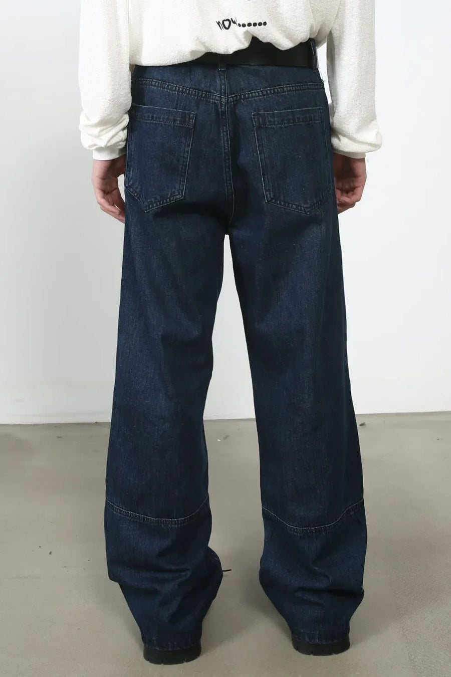 Dark wash denim wide-leg jeans with panel detail and distressed accents.