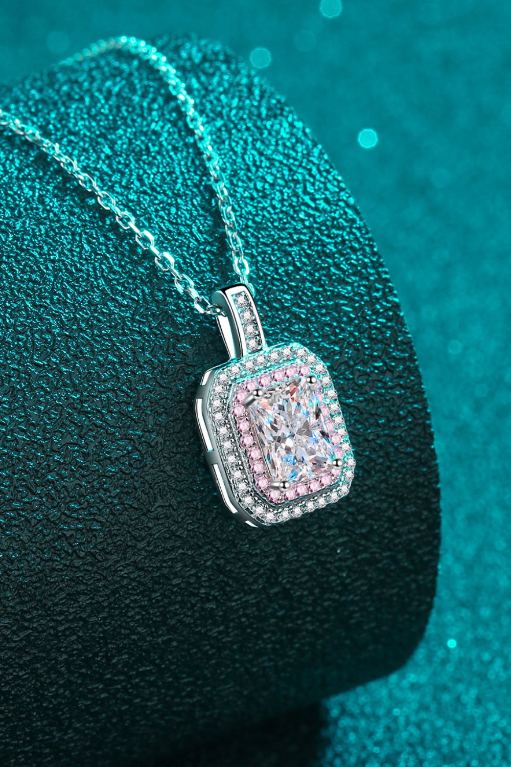 Silver radiant cut halo moissanite necklace with pink and white accent stones.