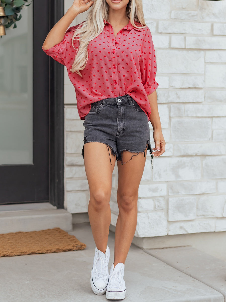 Pink button-down shirt with red heart pattern, cuffed sleeves, and classic collar.