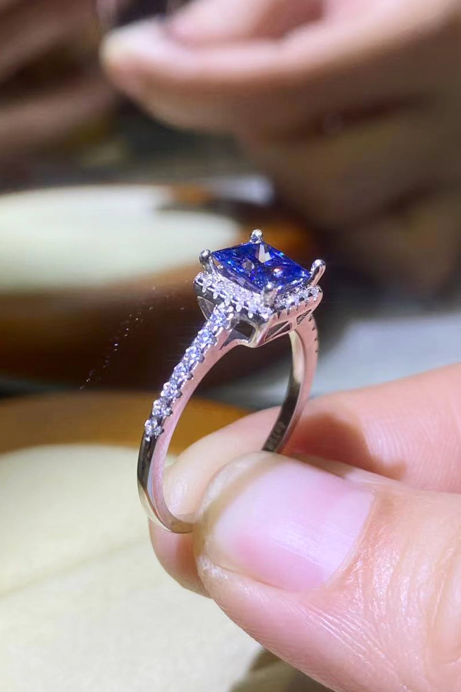 Blue sapphire square halo ring with pave diamond band.