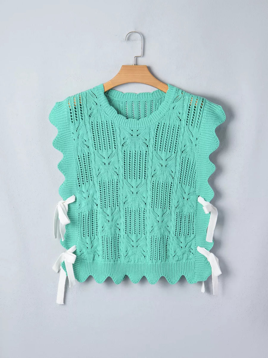Pointelle knit sweater vest in mint green with scalloped trim and white tie details on sides.
