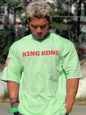 King Kong graphic oversized tee in Gum Leaf green with red text and sleeve detail.