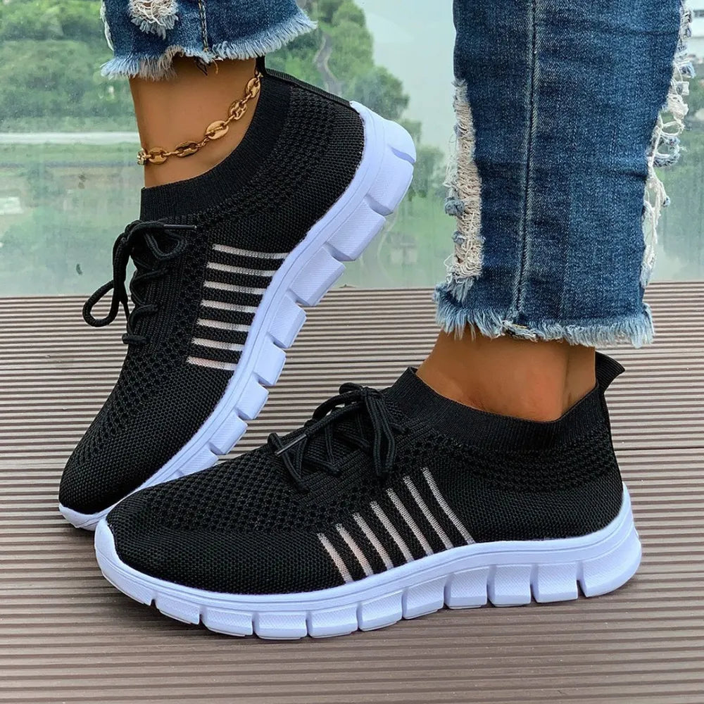 Black breathable knit runner sneakers with white stripe detail and white soles.