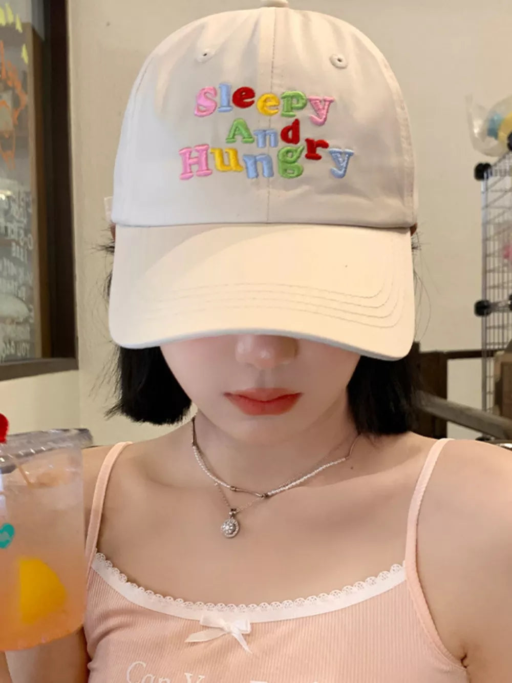 Beige cotton baseball cap with colorful embroidered "Sleepy And Hungry" text