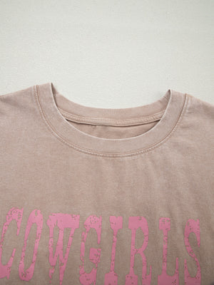 Acid-washed cotton tank top in Khaki with distressed pink "COWGIRLS" graphic.